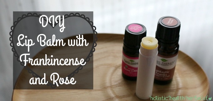 DIY Lip Balm with Frankincense and Rose - A homemade lip balm next to bottles of frankincense and rose essential oil.